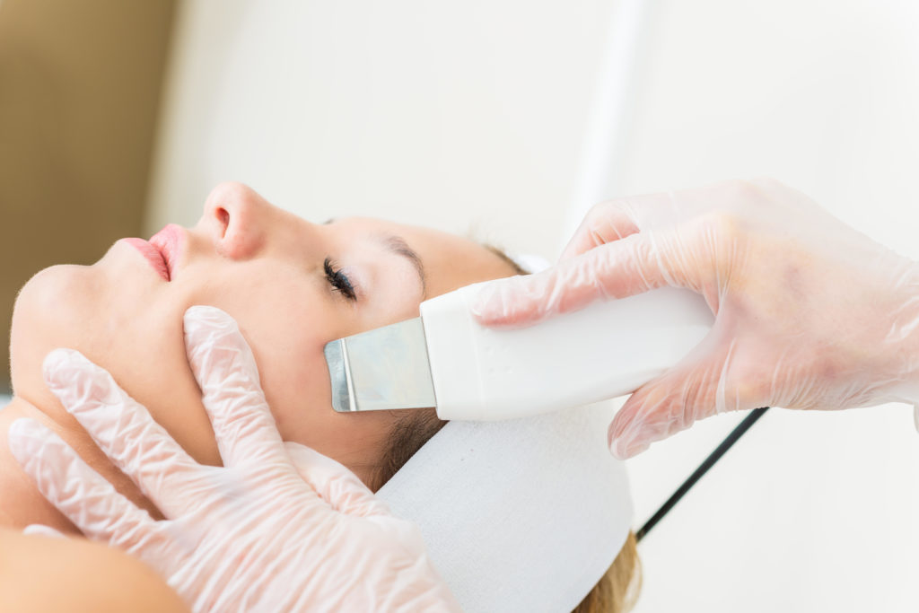 Woman getting ultrasound skin cleaning at beauty salon